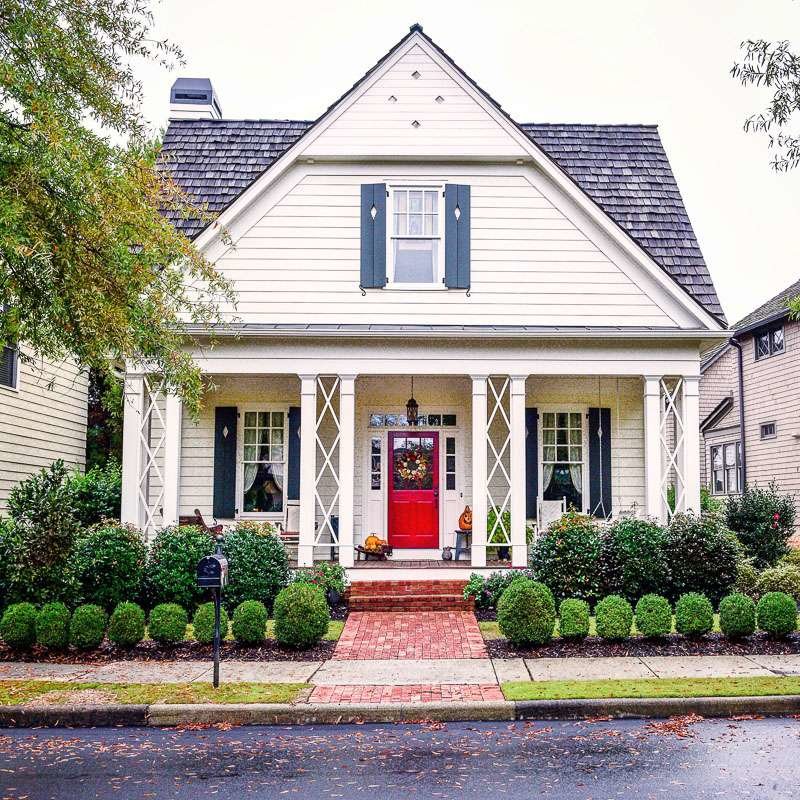Southern living white cottage with bright red door and porch